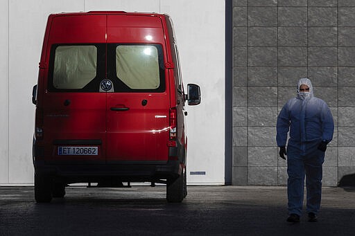 A spanish UME (Emergency Army Unit) soldier walks out of Madrid's ice rink turned into a temporary morgue due the COVID-19 crisis in Madrid, Spain, Monday, March 23, 2020. As cases in China ebbed, the dangers to Europe and the U.S. have grown exponentially, although Germany on Monday cautiously reported some flattening of its infection curve. More than 1.5 billion around the world have been told to stay in their homes. For most people, the new coronavirus causes only mild or moderate symptoms. For some it can cause a more serious illness. (AP Photo/Bernat Armangue)