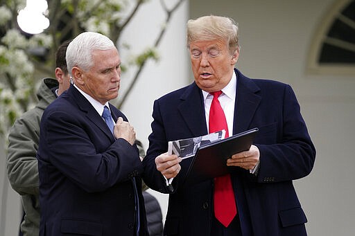 President Donald Trump speaks with Vice President Mike Pence as they arrive for a Fox News Channel virtual town hall, at the White House, Tuesday, March 24, 2020, in Washington. (AP Photo/Evan Vucci)