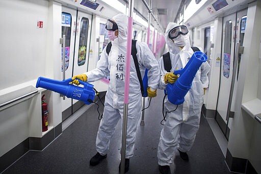 In this March 23, 2020 photo released by Xinhua News Agency, workers disinfect a subway train in preparation for the restoration of public transport in Wuhan, in central China's Hubei province. China's health ministry says Wuhan has now gone several consecutive days without a new infection, showing the effectiveness of draconian travel restrictions that are slowly being relaxed around the country. (Xiao Yijiu/Xinhua via AP)