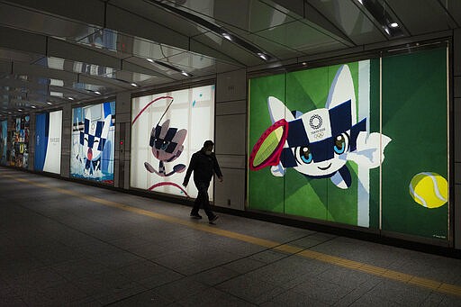 A man walks past large displays promoting the Tokyo 2020 Olympics in Tokyo, Tuesday, March 24, 2020. IOC President Thomas Bach has agreed &quot;100%&quot; to a proposal of postponing the Tokyo Olympics for about one year until 2021 because of the coronavirus outbreak, Japanese Prime Minister Shinzo Abe said Tuesday. (AP Photo/Jae C. Hong)