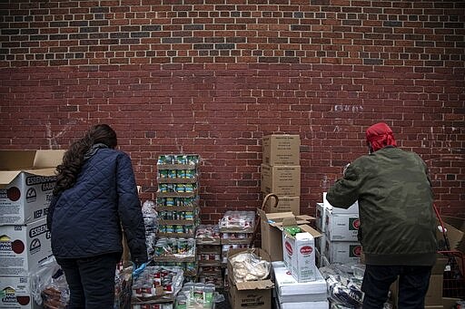 Volunteers prepare donations at St. Stephen Outreach in the Brooklyn borough of New York, on Friday, March 20, 2020. One out of four Americans volunteer, giving an estimated 8 billion hours a year of service. The most common work: collecting, preparing, distributing or serving food, according to the Bureau of Labor Statistics. (AP Photo/Wong Maye-E)