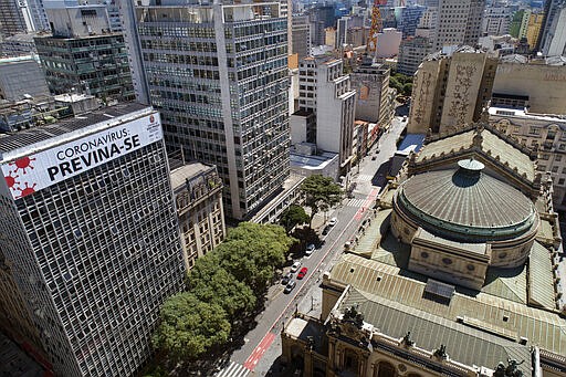 A building is covered by the Portuguese message: &quot;Coronavirus: take precaution&quot; over empty streets in downtown Sao Paulo, Brazil, Monday, March 23, 2020. (AP Photo/Andre Penner)