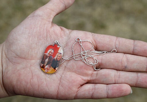 FILE - In this Feb. 25, 2020, file photo, Aya Al-Umari, whose brother Hussein Al-Umari was killed in the Al Noor mosque shooting, holds a pendant with a photo of herself and Hussein during an interview at her home in Christchurch, New Zealand. One year after killing 51 worshipers at two Christchurch mosques, an Australian white supremacist accused of the slaughter has changed his plea to guilty. Twenty-nine-year-old Brenton Harrison Tarrant on Thursday, March 26, 2020, pleaded guilty to 51 counts of murder, 40 counts of attempted murder and one count of terrorism. (AP Photo/Mark Baker, File)