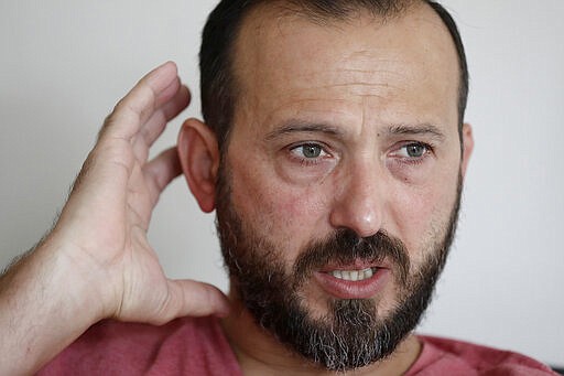 FILE - In this Feb. 25, 2020, file photo, Al Noor mosque shooting survivor Temel Atacocugu gestures during an interview at his home in Christchurch, New Zealand. One year after killing 51 worshipers at two Christchurch mosques, an Australian white supremacist accused of the slaughter has changed his plea to guilty. Twenty-nine-year-old Brenton Harrison Tarrant on Thursday, March 26, 2020 pleaded guilty to 51 counts of murder, 40 counts of attempted murder and one count of terrorism. (AP Photo/Mark Baker, File)