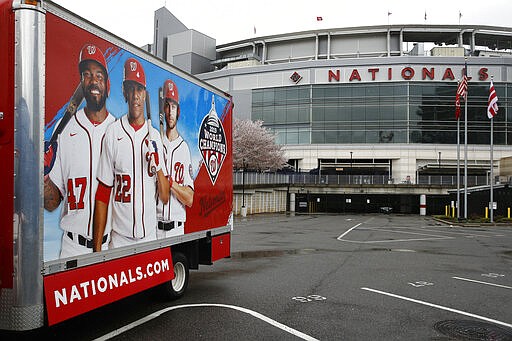 In this Wednesday, March 25, 2020, photo, a truck sits in a largely empty player's parking lot at Nationals Park in Washington. With the start of the Major League Baseball season indefinitely on hold because of the novel coronavirus pandemic, ballparks will be empty Thursday on what was supposed to be opening day.  (AP Photo/Patrick Semansky)