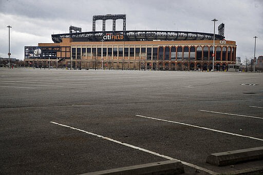 Parking lots sit empty surrounding Citifield, the home of the New York Mets, Wednesday, March 25, 2020, in the Queens borough of New York. There will be empty ballparks on what was supposed to be Major League Baseball's opening day. The start of the regular season is indefinitely on hold because of the coronavirus pandemic. (AP Photo/John Minchillo)