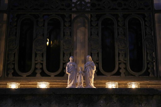 Candles are set up on a balcony in Versailles, Wednesday, March 25, 2020. France's bishops called for Catholics and non-Catholics alike to take part in Wednesday's candle-lighting, in a shared &quot;prayer for the dead, the sick and their loved ones, for all the medical personnel and all those who make the life of our country possible.&quot; The new coronavirus causes mild or moderate symptoms for most people, but for some, especially older adults and people with existing health problems, it can cause more severe illness or death. (AP Photo/Christophe Ena)