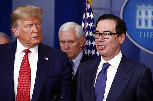 Treasury Secretary Steven Mnuchin speaks about the coronavirus in the James Brady Briefing Room, Wednesday, March 25, 2020, in Washington, as President Donald Trump listens. (AP Photo/Alex Brandon)