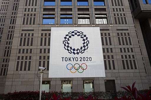 A banner promoting the Tokyo 2020 Olympics hands on the facade of the Tokyo Metropolitan Government building Wednesday, March 25, 2020, in Tokyo. Not even the Summer Olympics could withstand the force of the new coronavirus. After weeks of hedging, the IOC took the unprecedented step of postponing the world's biggest sporting event, a global extravaganza that's been cemented into the calendar for more than a century. (AP Photo/Jae C. Hong)