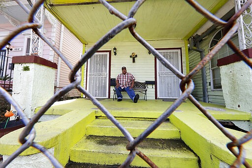 In this March 24, 2020, photo, David McGraw poses for a portrait as he sits on his front porch in New Orleans. Barely a week ago, McGraw was cooking daily for hundreds of fine diners at one of New Orleans&#146; illustrious restaurants. Today, he&#146;s cooking for himself, at home, laid off along with hundreds of thousands of people across the U.S. in a massive economic upheaval spurred by efforts to slow the spread of the coronavirus. (AP Photo/Gerald Herbert)