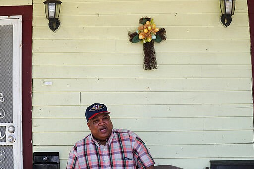 In this March 24, 2020, photo, David McGraw poses for a portrait as he sits on his front porch in New Orleans. Barely a week ago, McGraw was cooking daily for hundreds of fine diners at one of New Orleans&#146; illustrious restaurants. Today, he&#146;s cooking for himself, at home, laid off along with hundreds of thousands of people across the U.S. in a massive economic upheaval spurred by efforts to slow the spread of the coronavirus. (AP Photo/Gerald Herbert)