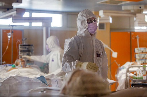 Medical staff of the Intensive Care Unit of the Casalpalocco COVID-19 Clinic in the outskirts of Rome tend to patients, Wednesday, March 25, 2020. The new coronavirus causes mild or moderate symptoms for most people, but for some, especially older adults and people with existing health problems, it can cause more severe illness or death. (AP Photo/Domenico Stinellis)