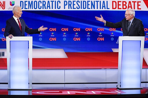 FILE - In this March 15, 2020, file photo former Vice President Joe Biden, left, and Sen. Bernie Sanders, I-Vt., right, participate in a Democratic presidential primary debate at CNN Studios in Washington. U.S. elections have been upended by the coronavirus pandemic. At least 13 states have postponed voting and more delays are possible as health officials warn that social distancing and other measures to contain the virus might be in place for weeks, if not months. (AP Photo/Evan Vucci, File)