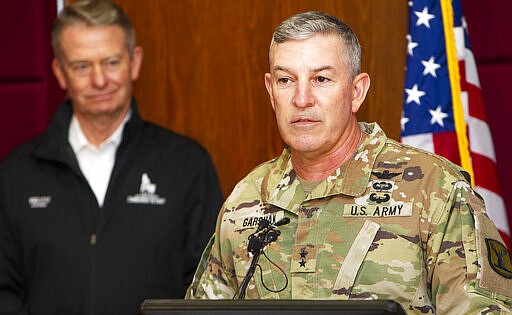 Maj. Gen. Michael J. Garshak, commanding the Idaho National Guard, introduces Idaho Gov. Brad Little after announcing a state of readiness for the emergency management response teams at a press conference updating the state's coronavirus plans, Wednesday, March 25, 2020 at Gowen Field in Boise, Idaho. (Darin Oswald/Idaho Statesman via AP)