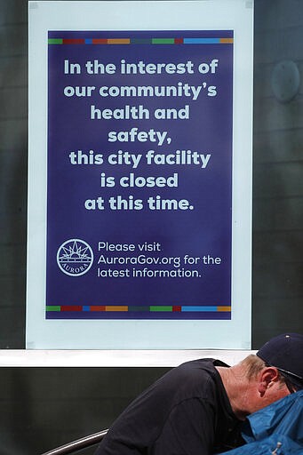 A closed sign hangs in the window of the Aurora Public Library as city buildings are closed to reduce the spread of the new coronavirus Wednesday, March 25, 2020, in Aurora, Colo. The new coronavirus causes mild or moderate symptoms for most people, but for some, especially older adults and people with existing health problems, it can cause more severe illness or death. (AP Photo/David Zalubowski)