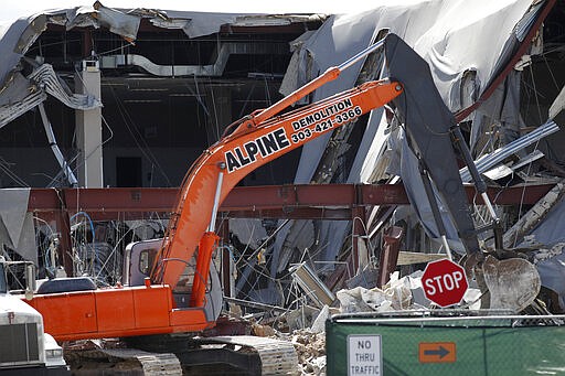 Demolition efforts carry on at the Aurora Mall as essential workers continue to toil in spite of the spread of the new coronavirus Wednesday, March 25, 2020, in Aurora, Colo. The new coronavirus causes mild or moderate symptoms for most people, but for some, especially older adults and people with existing health problems, it can cause more severe illness or death. (AP Photo/David Zalubowski)