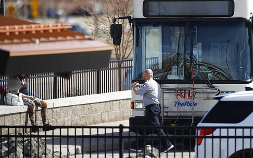 A driver for the Regional Transportation Distirct waves a lone passenger on to a waiting bus at the bus center as the district struggles with a deep drop in ridership because of the spread of the new coronavirus Wednesday, March 25, 2020, in Aurora, Colo. The new coronavirus causes mild or moderate symptoms for most people, but for some, especially older adults and people with existing health problems, it can cause more severe illness or death. (AP Photo/David Zalubowski)