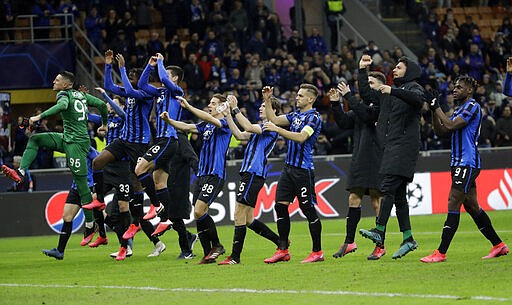 FILE - In this Wednesday, Feb. 19, 2020 file photo, Atalanta players celebrate at the end of the Champions League round of 16, first leg, soccer match between Atalanta and Valencia at the San Siro stadium in Milan, Italy. It was the biggest soccer game in Atalanta&#146;s history and a third of Bergamo&#146;s population made the short trip to Milan&#146;s famed San Siro Stadium to witness it. Nearly 2,500 fans of visiting Spanish club Valencia also traveled to the Champions League match. More than a month later, experts are pointing to the Feb. 19 game as one of the biggest reasons why Bergamo has become one of the epicenters of the coronavirus pandemic &#151; a &#147;biological bomb&#148; was the way one respiratory specialist put it &#151; and why 35% of Valencia&#146;s team became infected. The new coronavirus causes mild or moderate symptoms for most people, but for some, especially older adults and people with existing health problems, it can cause more severe illness or death. (AP Photo/Luca Bruno, File)