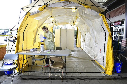 Courtney Grooms, right, waits for the next person to screen before they can enter the AnMed Health Campus Emergency entrance in Anderson, S.C. in Anderson Thursday, March 19, 2020. Persons authorized to get tested for Coronavirus are sent to another area outside the North campus on S.C. 81, at the AnMed Health Kirk Oglesby Health Campus.  (Ken Ruinard /The Independent-Mail via AP)