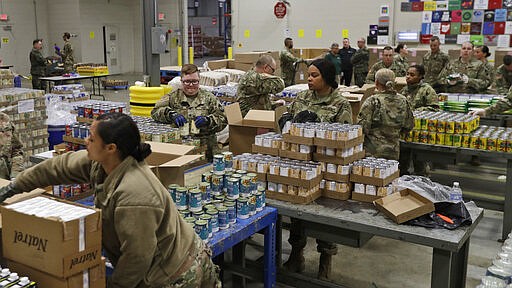 Members of The Ohio National Guard assist in repackaging emergency food boxes for food distribution at the Cleveland Food Bank, Tuesday, March 24, 2020, in Cleveland.  State parks have shuttered cabins, golf courses and marinas as Ohio enters its first full day of a statewide &#147;stay at home&#148; order to slow the spread of the coronavirus. Grocery stores, gas stations and other essential businesses remain open. (AP Photo/Tony Dejak)