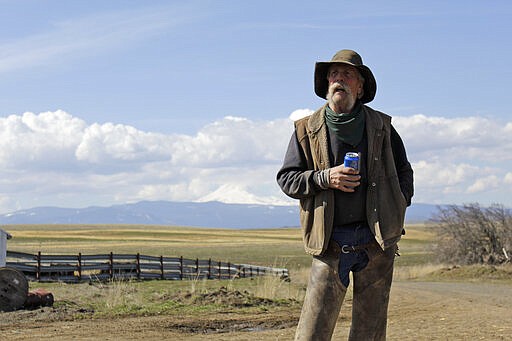 In this photo taken March 20, 2020, cattle rancher Mike Filbin stands on his property in Dufur, Ore., after herding some cows and talks about the impact the new coronavirus is having on his rural community. Tiny towns tucked into Oregon's windswept plains and cattle ranches miles from anywhere in South Dakota might not have had a single case of the new coronavirus yet, but their residents fear the spread of the disease to areas with scarce medical resources, the social isolation that comes when the only diner in town closes its doors and the economic free fall that's already hitting them hard. (AP Photo/Gillian Flaccus)