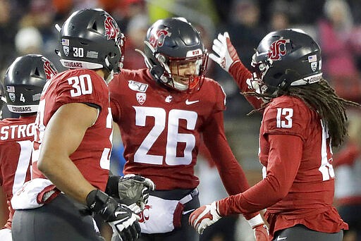 FILE - In this Nov. 23, 2019, file photo, Washington State defensive back Bryce Beekman (26) is greeted by defensive lineman Nnamdi Oguayo (30) and linebacker Jahad Woods (13) after Beekman intercepted an Oregon State pass during the first half of an NCAA college football game in Pullman, Wash. Bryce Beekman has died. Police Cmdr. Jake Opgenorth said Wednesday, Marc 25, 2020, the 22-year-old Beekman was found dead at a residence in Pullman. He declined to provide additional details and said more information would be released later by the Whitman County coroner&#146;s office. (AP Photo/Ted S. Warren, File)