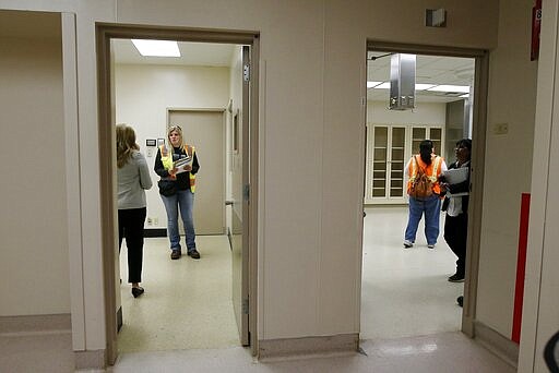 A group from the U.S. Army Corps of Engineers and the Arizona health department tour the currently closed St. Luke's Medical Center hospital to see the viability of reopening the facility for possible future use due to the coronavirus Wednesday, March 25, 2020, in Phoenix. (AP Photo/Ross D. Franklin)