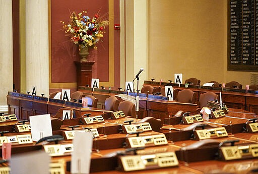 The House chamber at the state Capitol is empty Wednesday, March 18, 2020, in St. Paul, Minn., with some desks marked with an &quot;A&quot; - those desks may be occupied to maintain social distancing because of the coronavirus when lawmakers return. (Glen Stubbe/Star Tribune via AP)