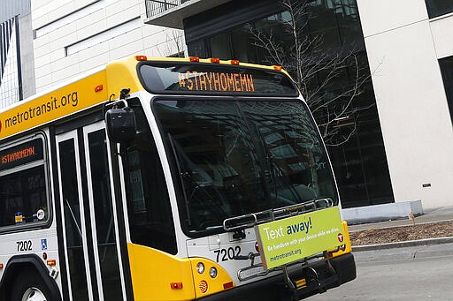 A Metrotransit bus uses the marquee to advise Minnesotans to stay home as it travels on the Nicollet Mall Wednesday, March 25, 2020, in Minneapolis, an effort to slow down the coronavirus in the state. The new coronavirus causes mild or moderate symptoms for most people, but for some, especially older adults and people with existing health problems, it can cause more severe illness or death. (AP Photo/Jim Mone)