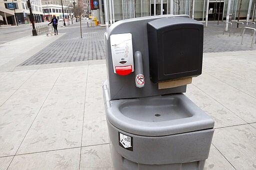 A portable hand washing unit with sanitizer sits on the Nicollet Mall Wednesday, March 25, 2020 in Minneapolis, as efforts to slow down the coronavirus in the state continue. The new coronavirus causes mild or moderate symptoms for most people, but for some, especially older adults and people with existing health problems, it can cause more severe illness or death. (AP Photo/Jim Mone)