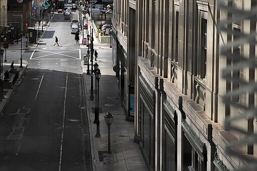 A lone pedestrian crosses at 8th and Market streets in Philadelphia on Tuesday, March 24, 2020. Non-essential businesses are closed and a stay-at-home order has been issued by the city, with the exception of those working for life-sustaining businesses, due to the spread of the coronavirus. (Heather Khalifa/The Philadelphia Inquirer via AP)