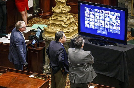 Senate Democratic Leader Jay Costa, D-Allegheny, center, stands near his chief of staff Tony Lapore, right, as they watch a monitor where a majority of senators have live-streamed the senate session, Wednesday, March 25, 2020, in Harrisburg, Pa. The state Senate is holding a session to vote on changing the primary election date, among other measures. The Senate session is the first in state history where members can meet online and vote remotely due to the coronavirus pandemic. (Dan Gleiter/The Patriot-News via AP)