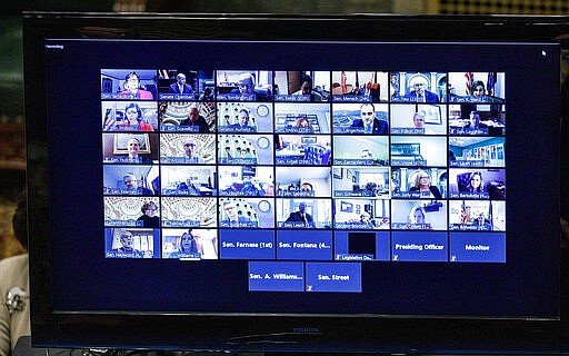 State senators are displayed on a monitor as they live-streamed the senate session, Wednesday, March 25, 2020, in Harrisburg, Pa. The state Senate is holding a session to vote on changing the primary election date, among other measures. The Senate session is the first in state history where members can meet online and vote remotely due to the coronavirus pandemic. (Dan Gleiter/The Patriot-News via AP)