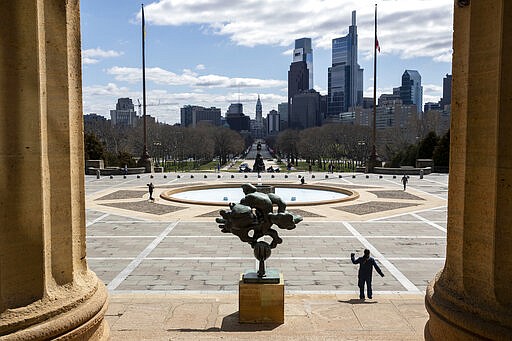 People exercise near the Art Museum stairs in Philadelphia on Tuesday, March 24, 2020. Gov. Tom Wolf on Monday ordered that schools remain closed until early April and issued a stay-at-home order for the seven counties that have been hardest hit by the coronavirus, that includes Philadelphia and the suburbs. (Monica Herndon/The Philadelphia Inquirer via AP)