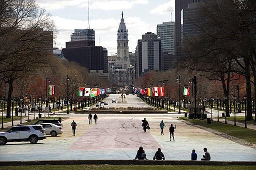 People exercise near the Art Museum stairs in Philadelphia on Tuesday, March 24, 2020. Gov. Tom Wolf on Monday ordered that schools remain closed until early April and issued a stay-at-home order for the seven counties that have been hardest hit by the coronavirus, including Philadelphia and its suburbs. (Monica Herndon/The Philadelphia Inquirer via AP)