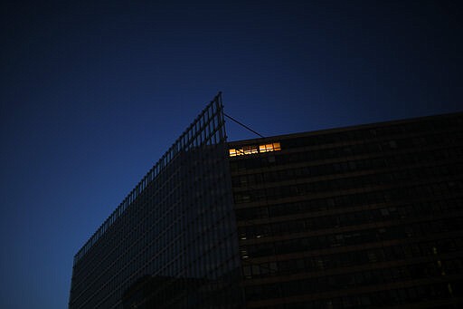 A light is on at the EU Charlemagne building during a partial lockdown ordered by Belgium government in Brussels, Monday, March 23, 2020. For some people the COVID-19 coronavirus causes mild or moderate symptoms, but for some it causes severe illness. (AP Photo/Francisco Seco)