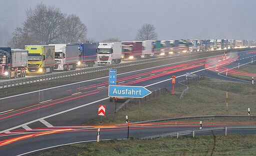 Trucks are jammed in the early morning on Autobahn 12 in front of the German-Polish border crossing near Frankfurt (Oder), Germany, Wednesday, March 18, 2020. In order to make it more difficult for the corona virus to spread, Poland had reintroduced controls at the border crossings to Germany. For most people, the new coronavirus causes only mild or moderate symptoms, such as fever and cough. For some, especially older adults and people with existing health problems, it can cause more severe illness, including pneumonia. (Patrick Pleul/dpa via AP)