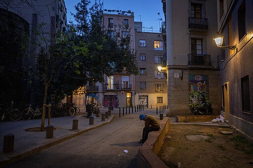 In this Friday, March 20, 2020 photo, Gana Gutierrez sits in an empty street in Barcelona, Spain. &quot;It is as if there has been a nuclear explosion and they are all sheltering in the bunker. Only us, the homeless, are left out &quot; explains 36-year-old Gana, who has lived on the street for more than 8 years and comments that the slogan. &quot;quedateencasa&quot; (Stayathome) is only for those who have a roof over their heads but not for them. (AP Photo/Emilio Morenatti)