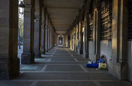 In this Friday, March 20, 2020 photo, Riccardo, 32, sits in empty arcades in downtown Barcelona, Spain. &quot;I thought I had seen everything during all these years sleeping in the street, but no. This silence on the street all day scares me... more than the virus itself ...&quot; says Riccardo, 32, who has been sleeping on the street for more than 10 years. (AP Photo/Emilio Morenatti)