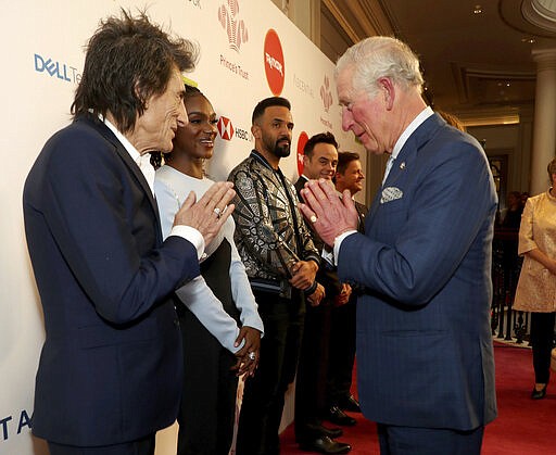 FILE - In this March 11, 2020 file photo, Britain's  Prince Charles, gesture as he greets musician Ronnie Wood as he arrives at the annual Prince's Trust Awards 2020 held at the London Palladium, Wednesday March 25, 2020. Prince Charles, the heir to the British throne, has tested positive for the new coronavirus.
The prince&#146;s Clarence House office reported on Wednesday, March 25, 2020 that the 71-year-old is showing mild symptoms of COVID-19 and is self-isolating at a royal estate in Scotland. It says his wife Camilla has tested negative. (Yui Mok/PA via AP, File)