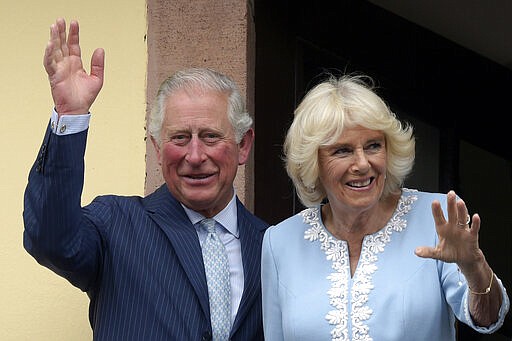 FILE - In this Wednesday, May 8, 2019 file photo, Britain's Prince Charles and Camilla, Duchess of Cornwall wave from the town hall balcony in Leipzig, Germany. Prince Charles, the heir to the British throne, has tested positive for the new coronavirus. The prince&#146;s Clarence House office reported on Wednesday, March 25, 2020 that the 71-year-old is showing mild symptoms of COVID-19 and is self-isolating at a royal estate in Scotland. It says his wife Camilla has tested negative. (AP Photo/Jens Meyer, File)