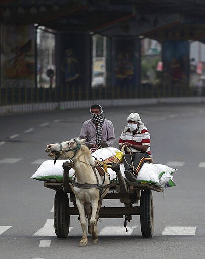 A man rides a horse cart during lockdown in Jammu, India, Wednesday, March 25, 2020. The world's largest democracy went under the world's biggest lockdown Wednesday, with India's 1.3 billion people ordered to stay home in a bid to stop the coronavirus pandemic from spreading and overwhelming its fragile health care system as it has done elsewhere. For most people, the new coronavirus causes mild or moderate symptoms, such as fever and cough that clear up in two to three weeks. For some, especially older adults and people with existing health problems, it can cause more severe illness, including pneumonia and death. (AP Photo/Channi Anand)