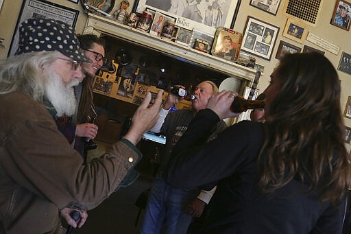 Patrons have beers at the R and R Bar in Idaho Falls, Idaho, Wednesday, March 25, 2020. Gov. Brad Little issued a stay-home order Wednesday for Idaho residents for the next 21 days. The order requires Idaho's 1.75 million residents to self-isolate at home unless they are healthcare workers, public safety employees or other &#147;essential workers&#148; such as grocery store employees.( John Roark/The Idaho Post-Register via AP)