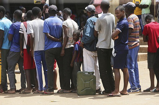 People join a queue to buy maize meal at a supermarket in Harare, Zimbabwe, Wednesday, March 25, 2020. Zimbabwe's public hospital doctors went on strike Wednesday over what they called a lack of adequate protective gear as the coronavirus begins to spread in a country whose health system has almost collapsed.  The new coronavirus causes mild or moderate symptoms for most people, but for some, especially older adults and people with existing health problems, it can cause more severe illness or death. (AP Photo/Tsvangirayi Mukwazhi) ///