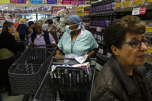 Shoppers make their way through a supermarket in Johannesburg, Wednesday, March 25, 2020 before the country of 57 million people, will go into a nationwide lockdown for 21 days from Thursday to fight the spread of the new coronavirus. For most people the virus causes only mild or moderate symptoms . For others it can cause more severe illness, especially in older adults and people with existing health problems. (AP Photo/Denis Farrell)