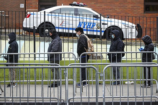 Patients maintain social distancing while they wait in line for a COVID-19 test at Elmhurst Hospital Center, Wednesday, March 25, 2020, in New York. Gov. Andrew Cuomo sounded his most dire warning yet about the coronavirus pandemic Tuesday, saying the infection rate in New York is accelerating and the state could be as close as two weeks away from a crisis that sees 40,000 people in intensive care. Such a surge would overwhelm hospitals, which now have just 3,000 intensive care unit beds statewide. (AP Photo/John Minchillo)