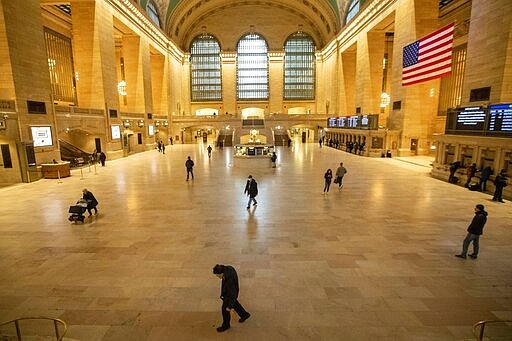 People make their way inside Grand Central Terminal, Wednesday, March 25, 2020, in New York. Hospitalizations from COVID-19 were rising faster than expected in New York as residents and leaders prepared for a peak in cases that is expected to still be weeks away. Temporary hospitals, and even a morgue in Manhattan, are being setup. (AP Photo/Mary Altaffer)