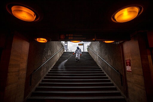 A municipal worker disinfects the subway stairs to prevent the spread of the coronavirus pandemic in Budapest, Hungary, Wednesday, March 25, 2020. The new coronavirus causes mild or moderate symptoms for most people, but for some, especially older adults and people with existing health problems, it can cause more severe illness or death. (Marton Monus/MTI via AP)