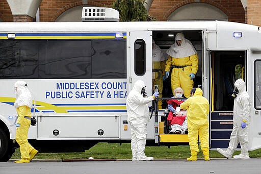 Residents from St. Joseph's Senior Home are helped onto buses in Woodbridge, N.J., Wednesday, March 25, 2020. More than 90 residents of the nursing home are being transferred to a facility in Whippany after 24 tested positive for COVID-19, according to a spokeswoman for CareOne, which operates the Whippany facility. The facility has moved its residents to other facilities to accommodate the new arrivals. (AP Photo/Seth Wenig)