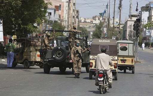 Pakistani troops stop vehicles to implement a lockdown in an effort to contain the outbreak of the coronavirus in Karachi, Pakistan, Tuesday, March 24, 2020. Pakistani authorities meanwhile said they'd shut down train operations across the country from Wednesday until March 31 in an effort to contain the spread of the virus. (AP Photo/Fareed Khan)